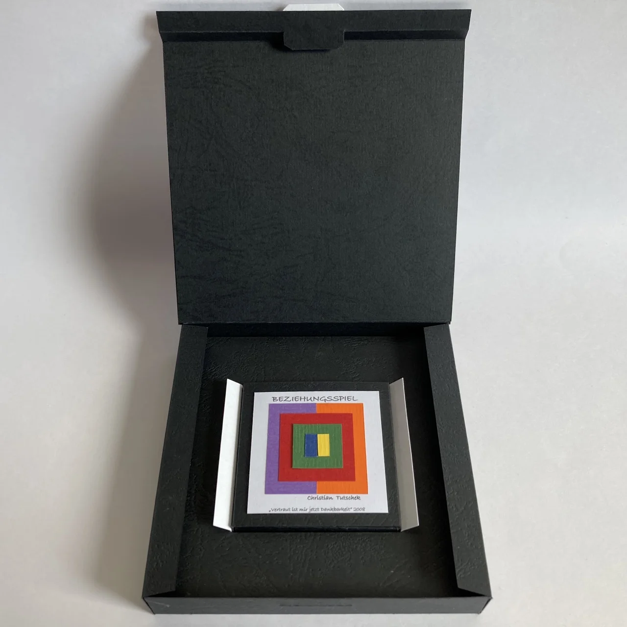 Geöffnete Verpackung mit Beziehungsspiel in Buchform